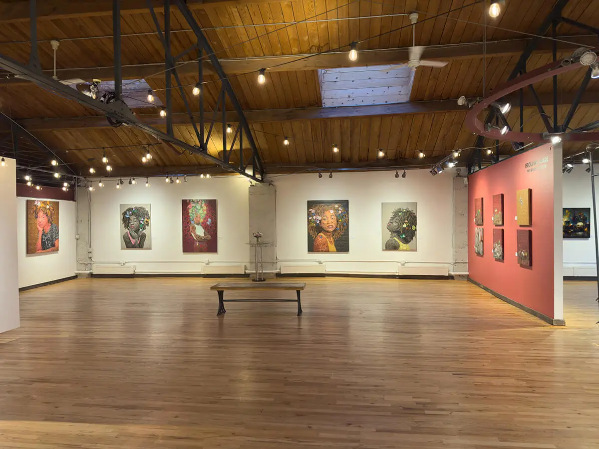 Back wall of Abend Gallery during The Sprout of Hope, showcasing large portraits by Ifeoluwa Alade. From left to right: Beulah, Still I Rise (2), Oasis, and Still I Rise (1). Each painting highlights themes of resilience, femininity, and growth through bold color and intricate detail. Skylight above provides soft natural light.